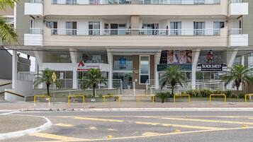 A multi-story building with a commercial ground floor featuring various businesses, including a bank and a convenience store.