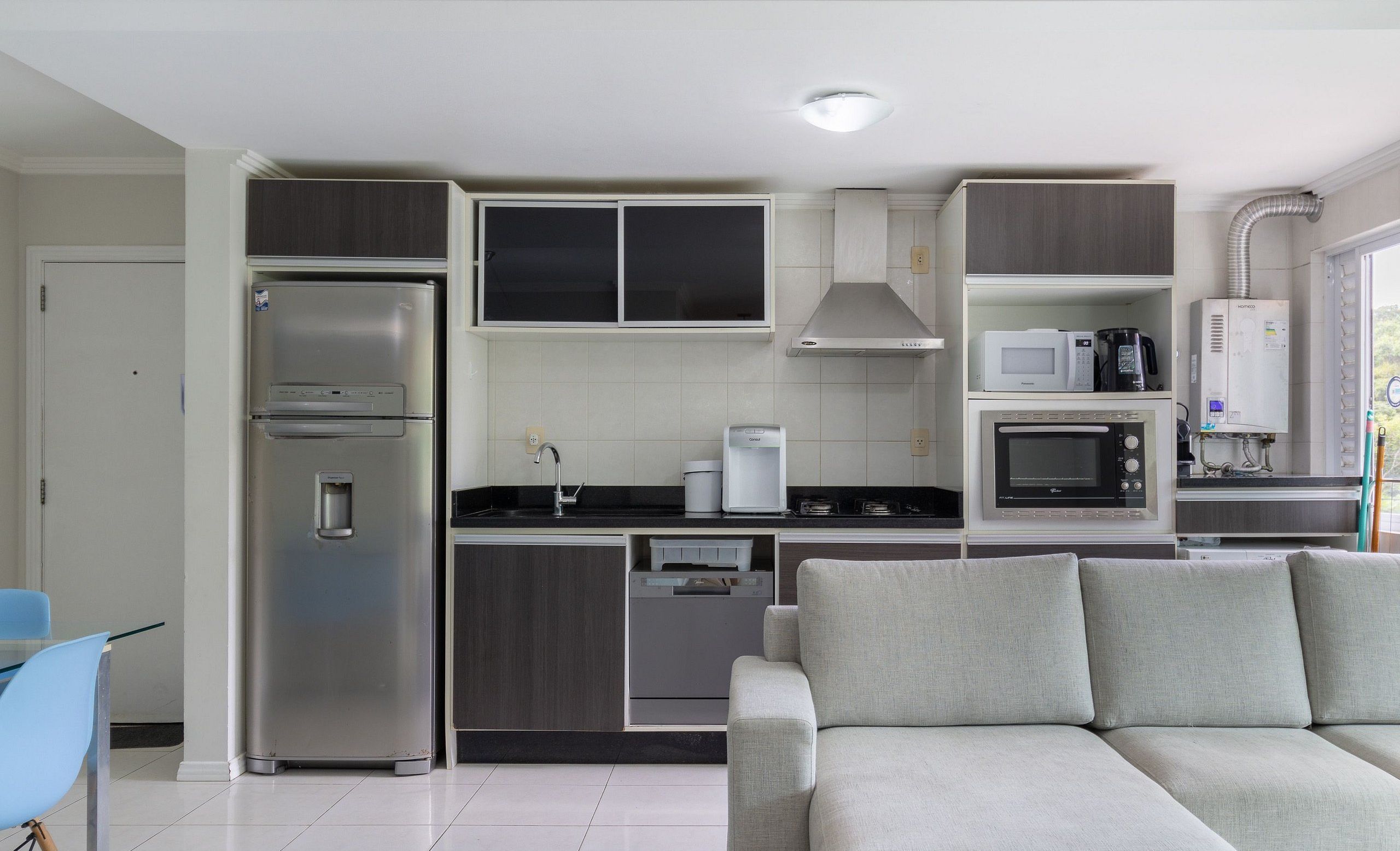 A compact kitchen with a built-in refrigerator, microwave, and dishwasher.
