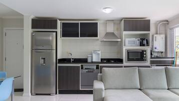 A compact kitchen with a built-in refrigerator, microwave, and dishwasher.