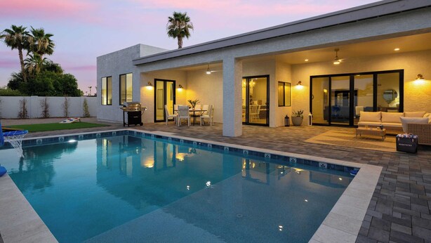 A modern house with a swimming pool, outdoor seating, and a patio area. - El Dorado by Avantstay Luxe 4BR w/ Pool, Putting Green, Fireplace Near Kierland (Scottsdale)