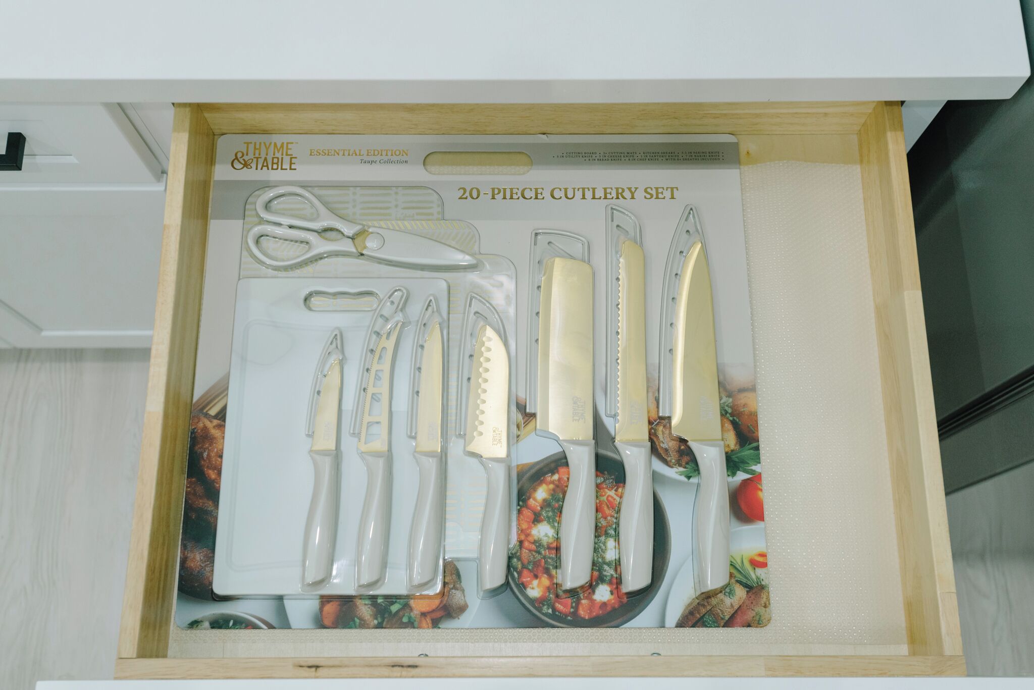A drawer containing a 20-piece cutlery set with various utensils including scissors, knives, and a cutting board.