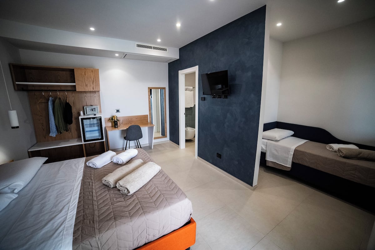 Luxury Triple Room, Pool View | Minibar, in-room safe, desk, blackout drapes
