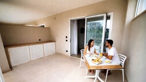 A modern kitchen with white cabinets and a wooden countertop. - Essenza Mediterranea Tropea (Tropea)