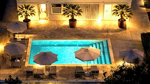 A two-story building with a swimming pool, outdoor seating, and potted plants. - Essenza Mediterranea Tropea (Tropea)