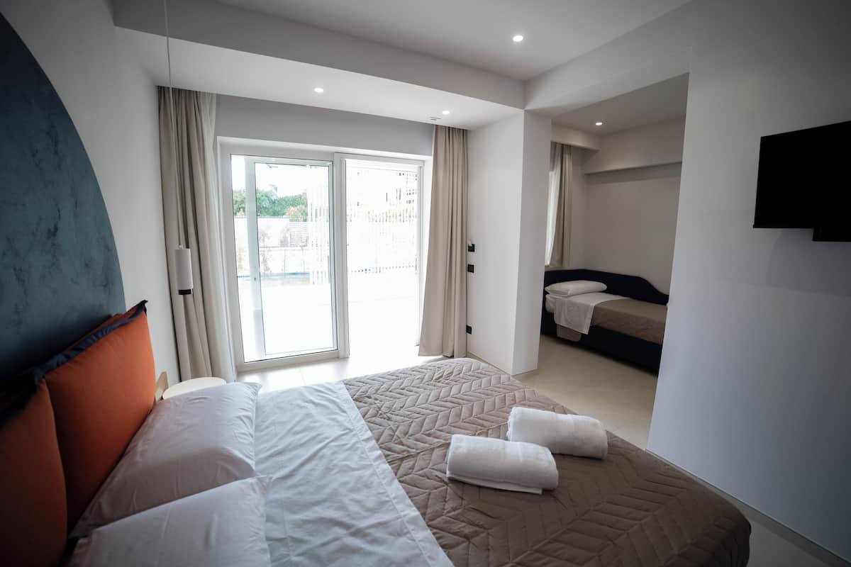 Comfort Triple Room, Garden View | Minibar, in-room safe, desk, blackout drapes