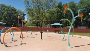 Un'area giochi all'aperto con strutture colorate e astratte e un tavolo da picnic.