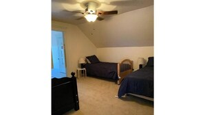A bedroom with two beds, a ceiling fan, and a door. - -Beautiful 4.5 BR / 4 Ba home with 2 car garage (Cushing)