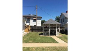 A backyard with a wooden deck, a gazebo, and a well-maintained lawn. - -Beautiful 4.5 BR / 4 Ba home with 2 car garage (Cushing)