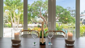 Un tavolo con una bottiglia di champagne Chandon Brut, due calici e una candela.