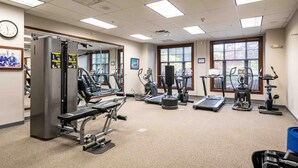 A gym with various exercise equipment, a clock on the wall, and large windows. - Heated Pool Hot Tubs Sauna Gym Mtn Front Appalachian @ Mtn Creek #428 (Vernon)