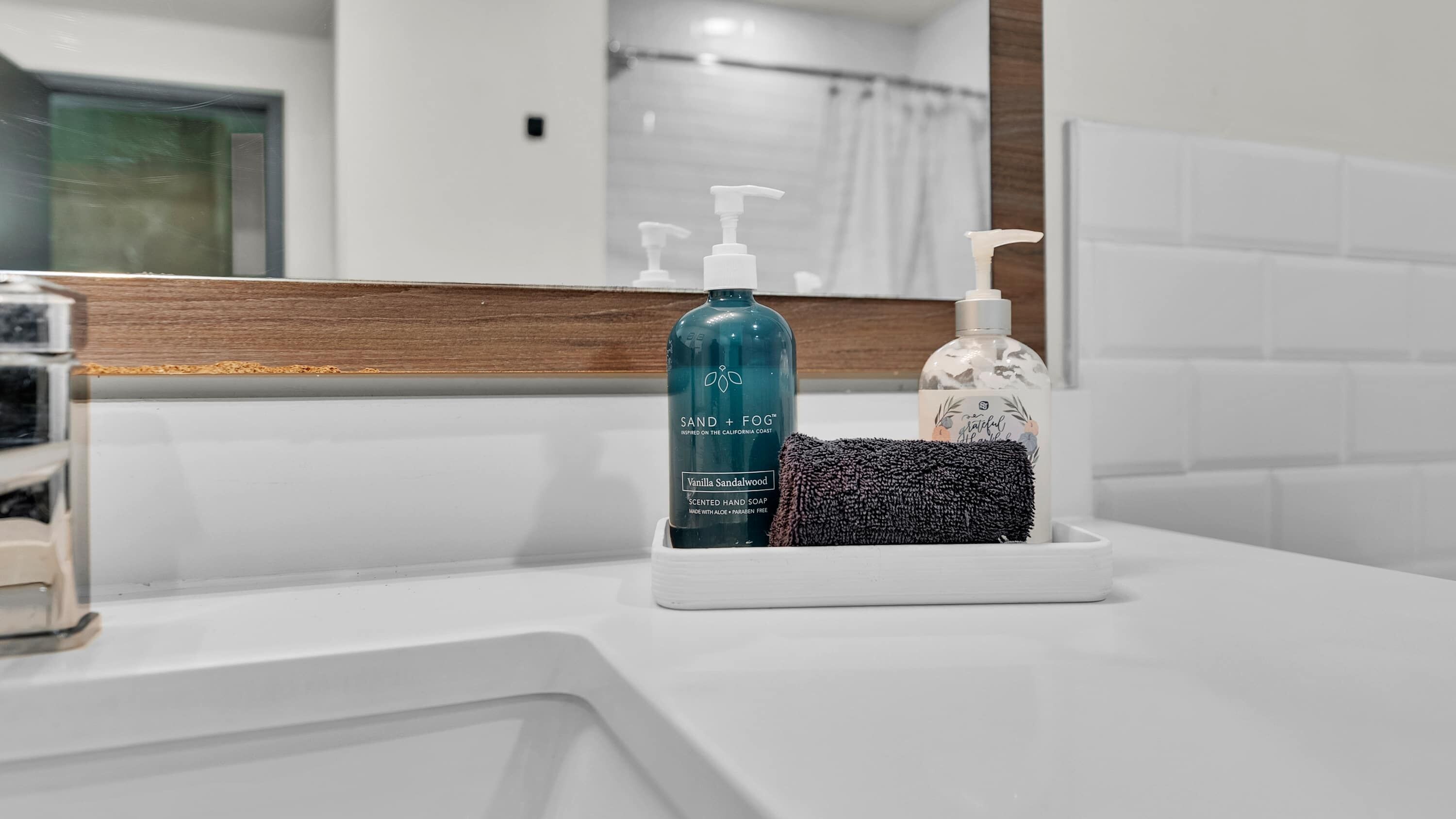 A bathroom counter with a soap dispenser and a hand towel.
