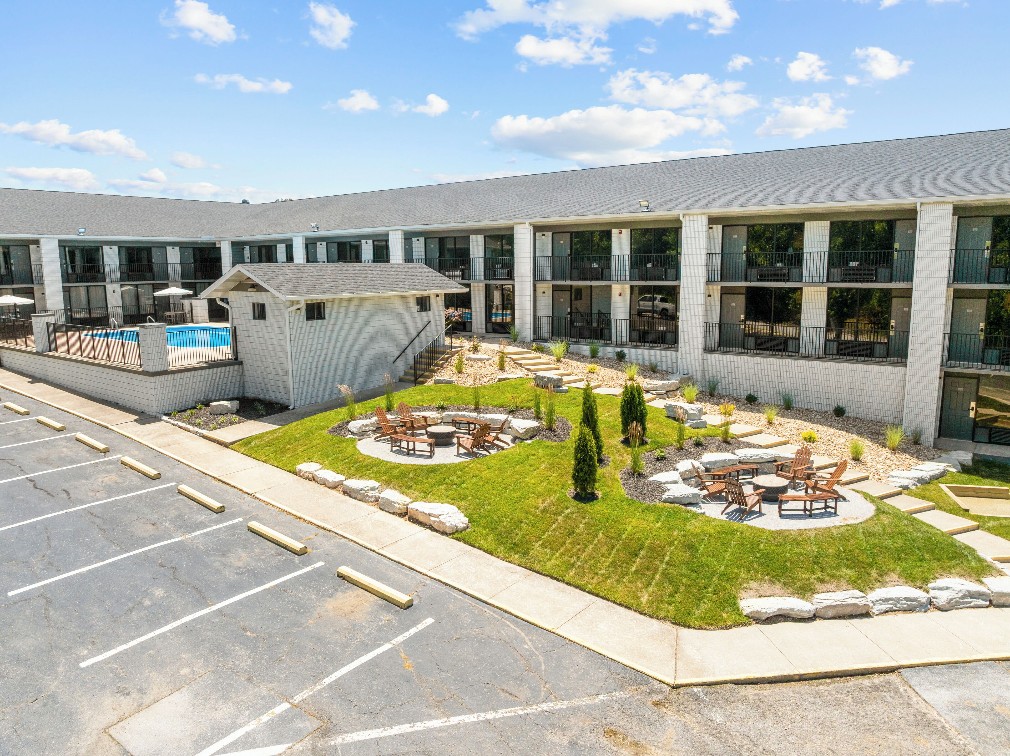 Um edifício moderno com piscina, área de estar externa e jardim paisagístico.