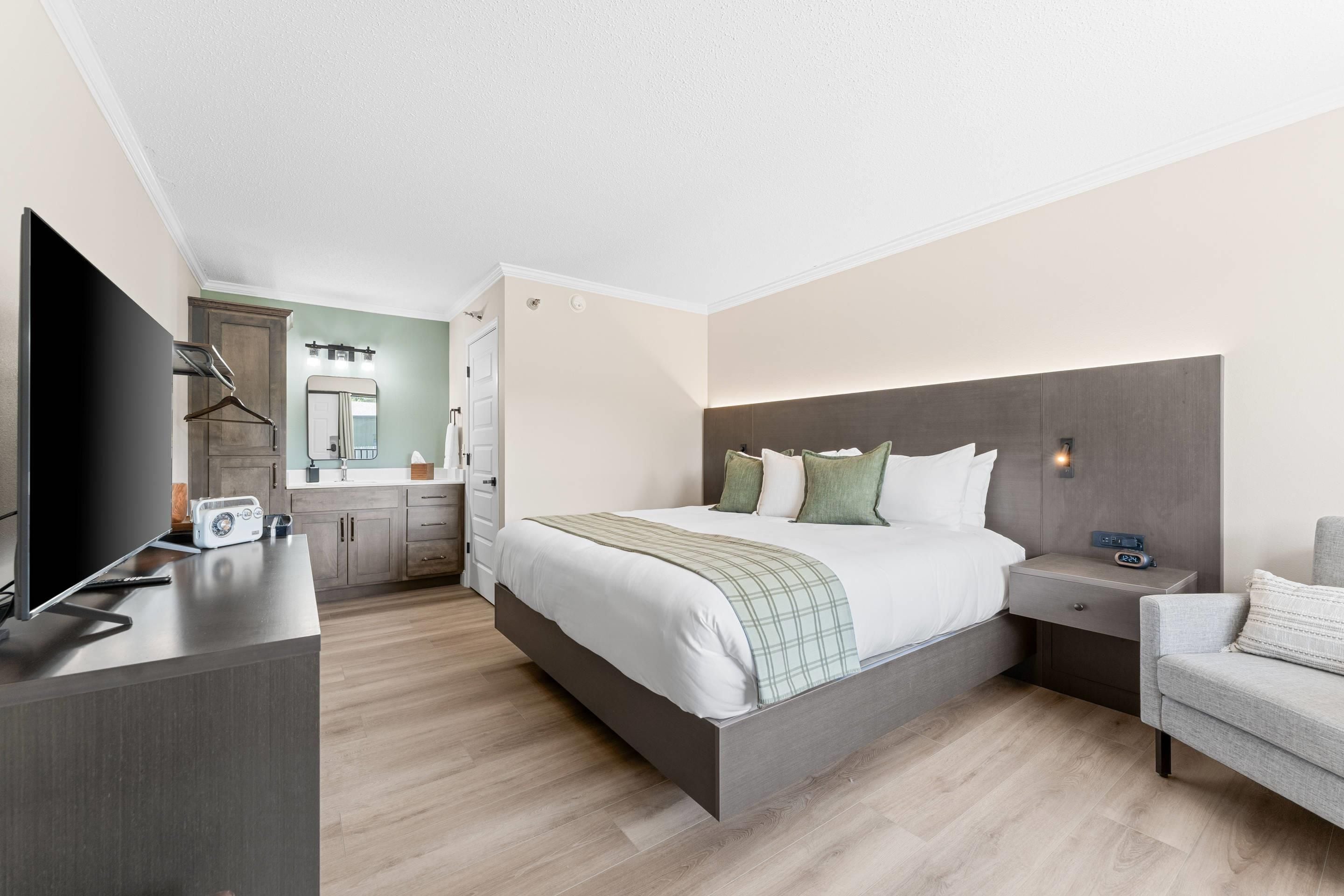 Une chambre d’hôtel moderne équipée d’un grand lit, d’une télévision, d’un bureau et d’une chaise.