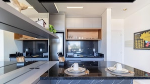 Una cocina moderna con una isla central, electrodomésticos integrados y un comedor con vistas.