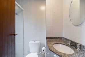 Une salle de bain avec des toilettes, un lavabo et un miroir.
