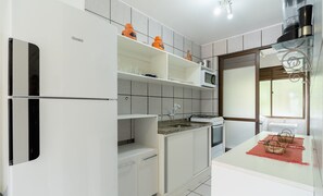 Eine moderne Küche mit weißen Schränken, einer eingebauten Mikrowelle und einem Gasherd.