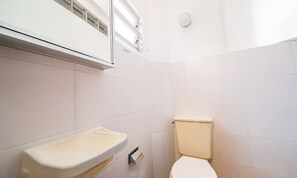A small bathroom with a toilet, a sink, and a window. - Seafront Beautiful House in Sto. Antonio Cda1647 (Florianópolis)