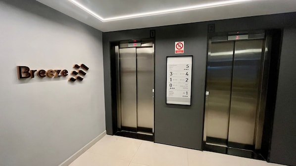 An elevator with a digital display and a sign indicating no smoking.