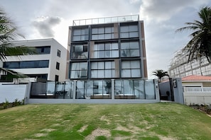 A modern multi-story building with large windows and a flat roof.