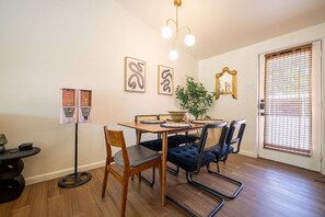 A dining area with a wooden table, chairs, and a potted plant.