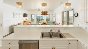 A spacious kitchen with a large island, stainless steel appliances, and pendant lighting.