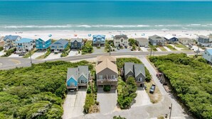 A coastal residential area with houses, a beach, and a road.
