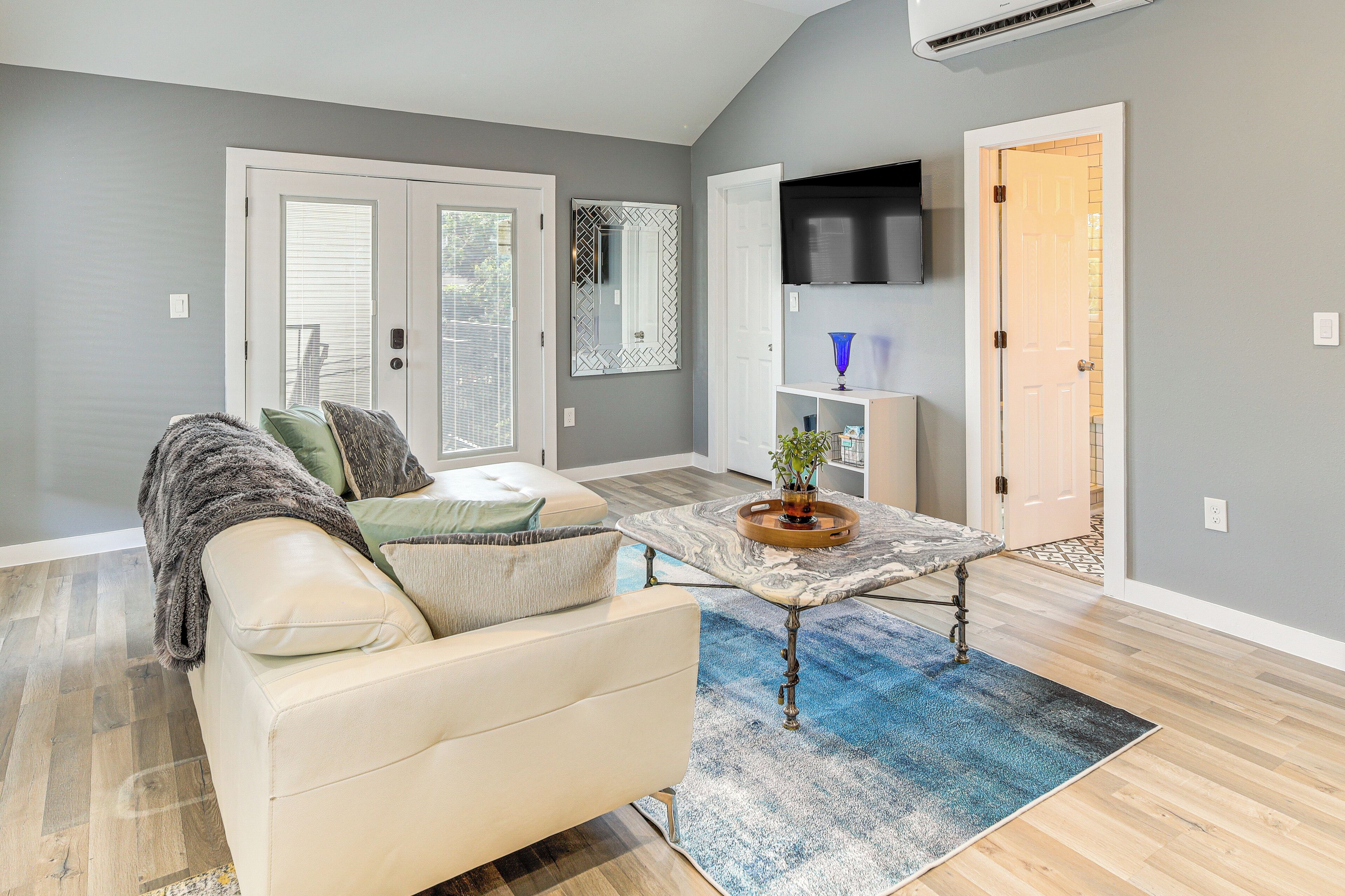 A living room with a sofa, a coffee table, and a TV.