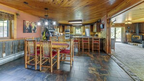 Un interior rústico de madera con comedor, cocina y bar.