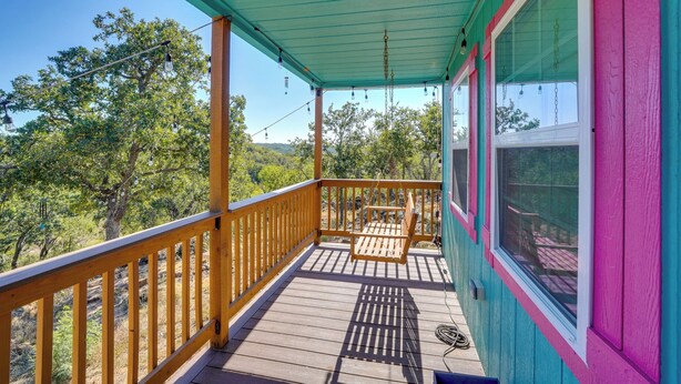 Una terraza de madera con vistas a árboles y colinas.