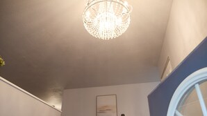 Un intérieur moderne agrémenté d’un lustre, d’un tableau et d’un escalier.