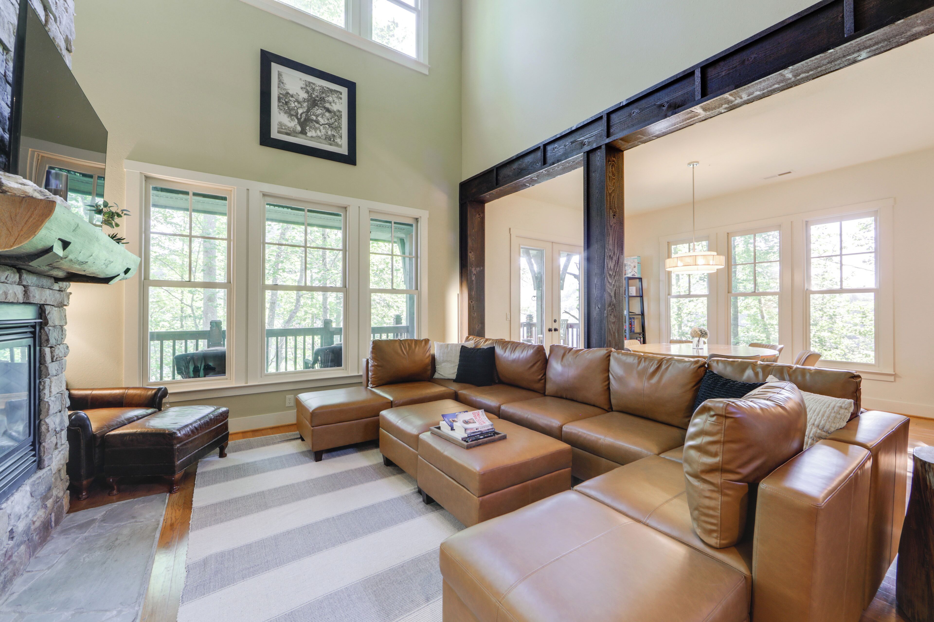 A spacious living room with a large sectional sofa, a fireplace, and large windows.