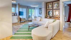 A modern living room with a sofa, coffee table, and artwork on the wall.