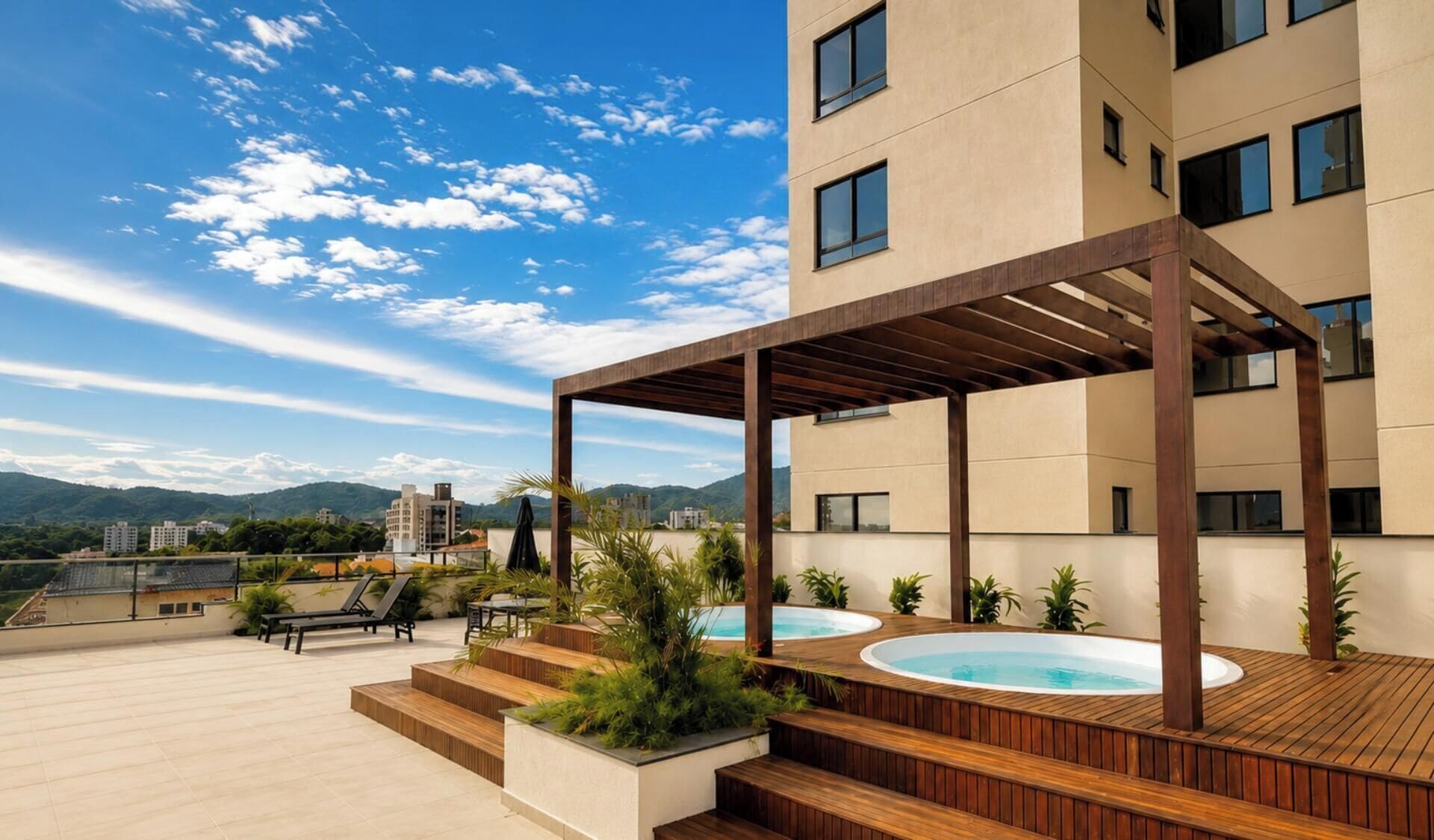 A rooftop terrace with a wooden deck, two hot tubs, and a pergola structure.