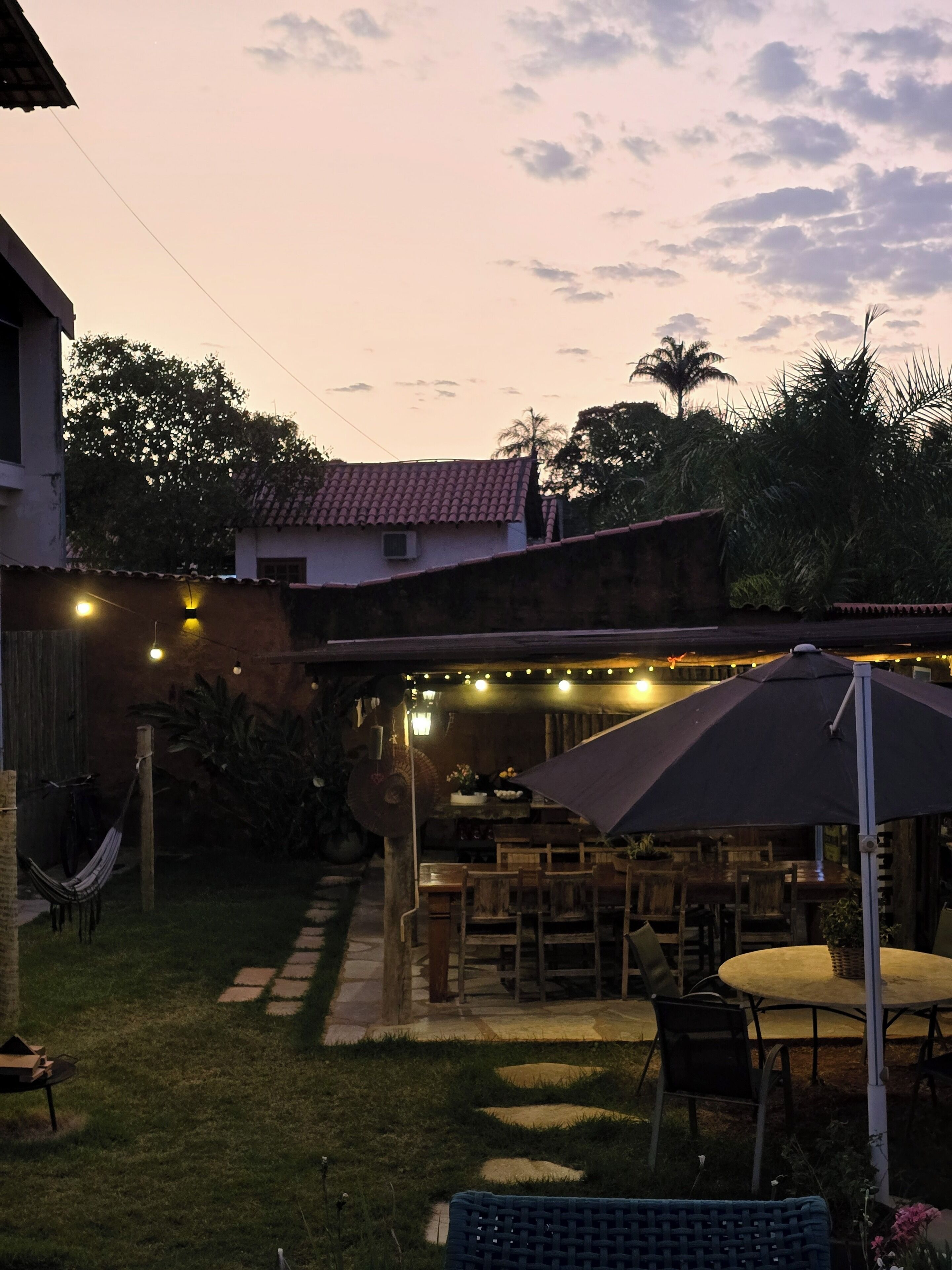 A patio area with outdoor seating, a hammock, and string lights.