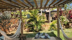 A hammock under a wooden pergola with a view of a garden and a house. - Confraria Da Prata Flats (Pirenópolis)