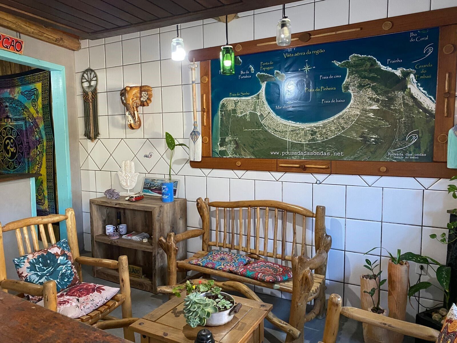 A cozy interior with wooden furniture, a map on the wall, and a small table with a plant.