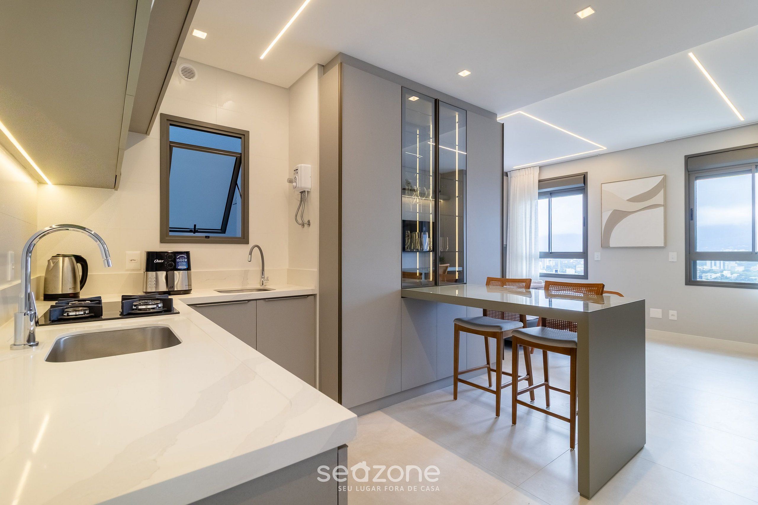 A modern kitchen with a large island, built-in appliances, and a dining area with bar stools.