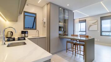 A modern kitchen with a large island, built-in appliances, and a dining area with bar stools.