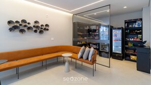 Ein modernes Interieur mit einer gebogenen Couch, einem kleinen runden Tisch und einer Wandleuchte.