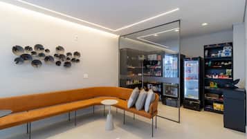 A modern interior with a curved sofa, a small round table, and a wall-mounted light fixture.