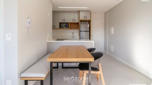 Eine moderne Küche mit Holztisch und Stühlen, einer Mikrowelle und einem Kühlschrank.