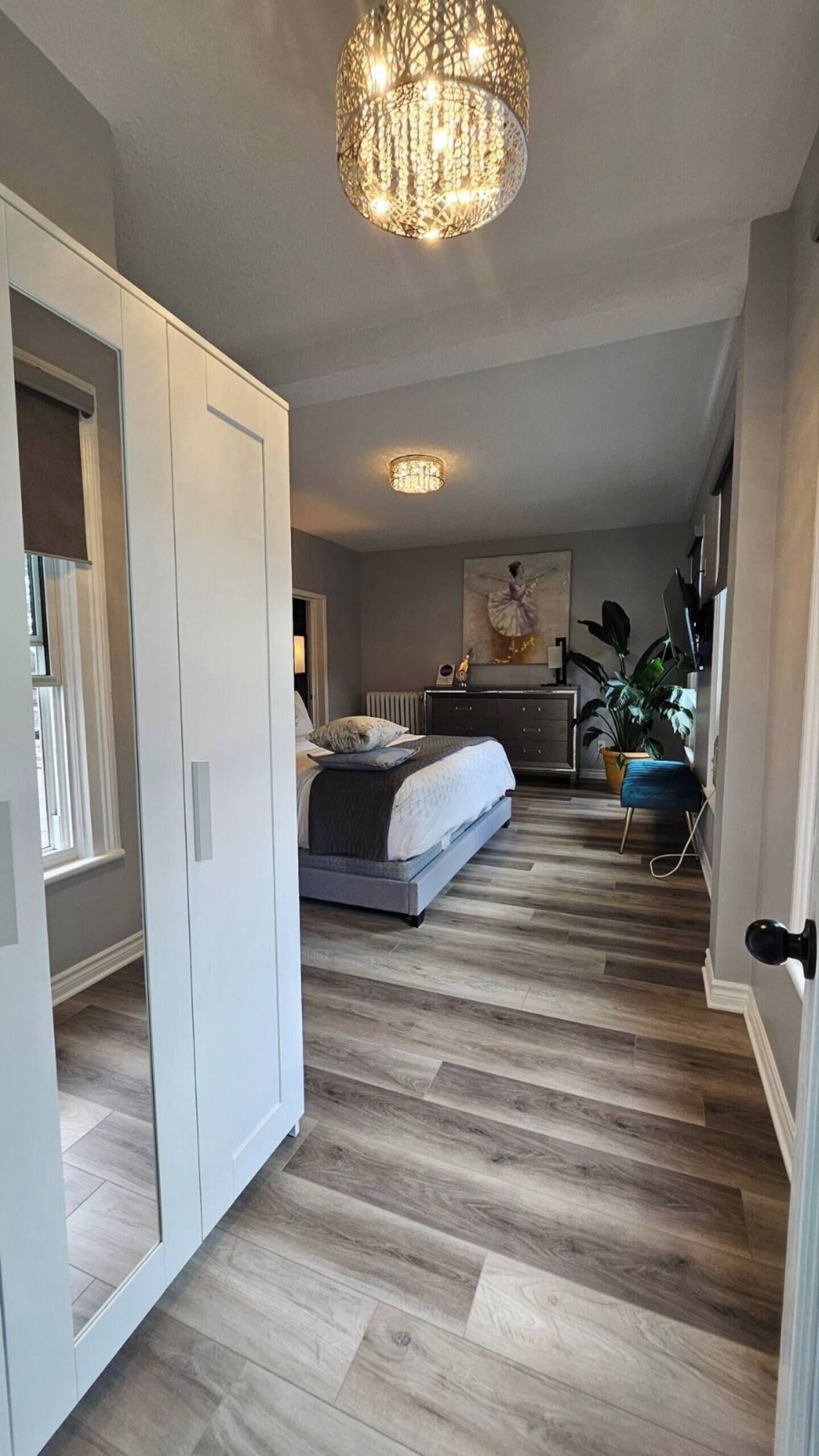 Une chambre à coucher avec un lit, une table de chevet et un lustre.