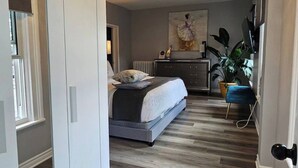 Un dormitorio con cama, mesita de noche y una araña.