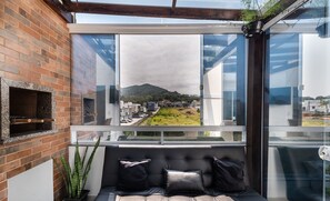 Een balkon met uitzicht op een stadsbeeld en een berg.