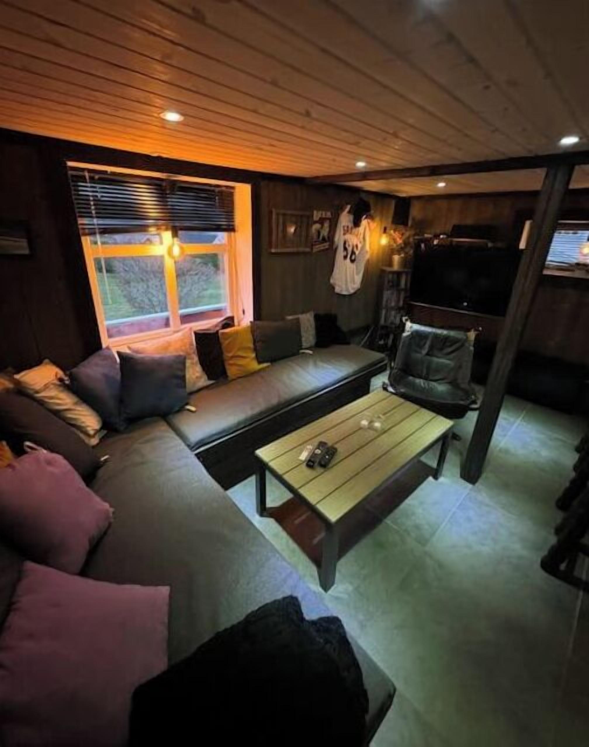 A cozy living room with a sofa, a coffee table, and a TV.