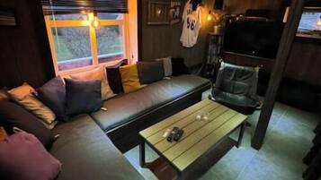 A cozy living room with a sofa, a coffee table, and a TV.