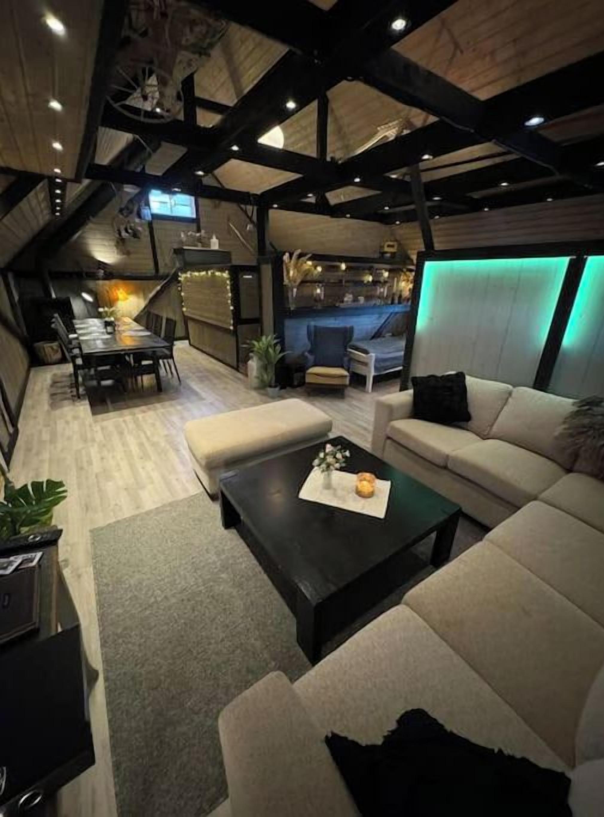 Een moderne woonkamer met een bank, salontafel en een aan de muur bevestigde televisie.