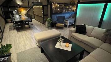Een moderne woonkamer met een bank, salontafel en een aan de muur bevestigde televisie.