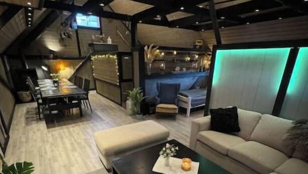 Una sala de estar moderna con un sofá, una mesa de centro y un televisor montado en la pared.