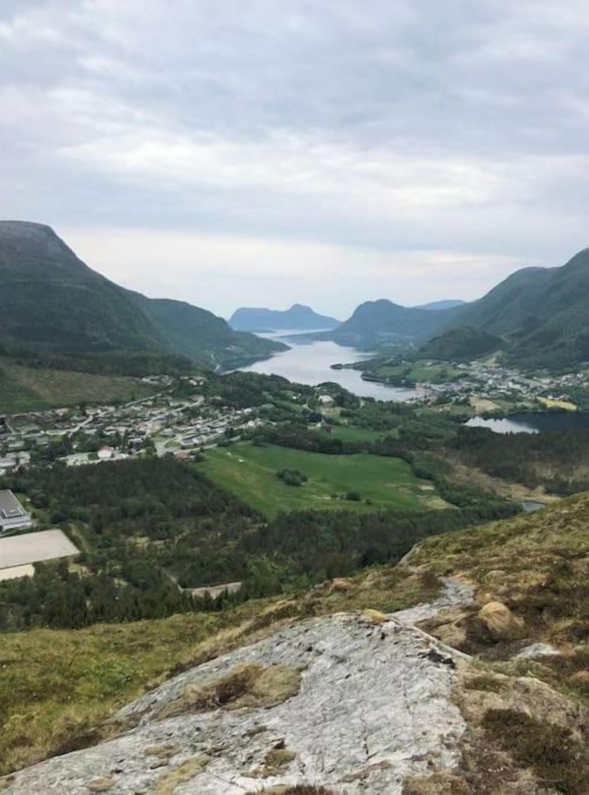 Un paisaje montañoso con un río y un pueblo.